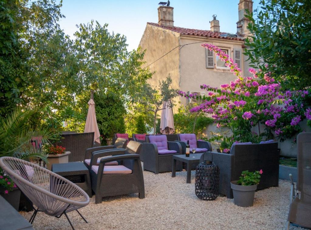 a patio with chairs and tables and flowers at Pula Garden Apartments with Shared Pool in Pula