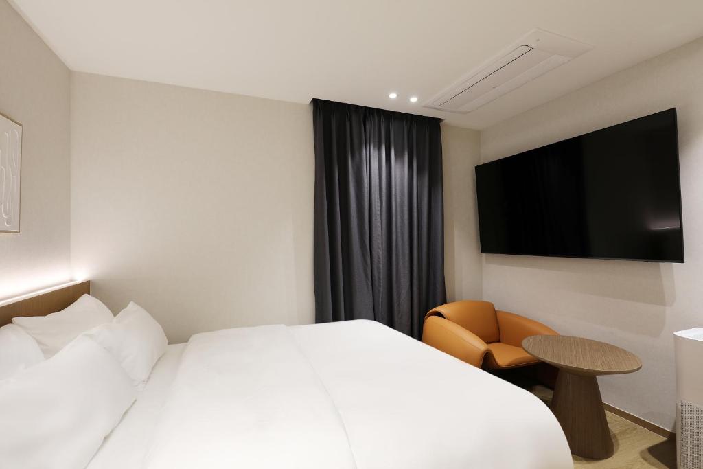 a hotel room with a bed and a television at 부천 브라운도트 호텔 부천역점 in Sosa