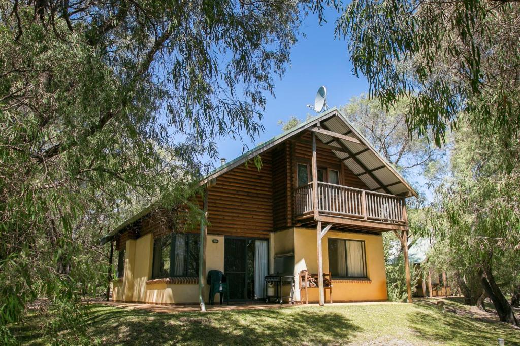 a house with a wrap around porch and a balcony at Wyadup Brook Cottages in Yallingup