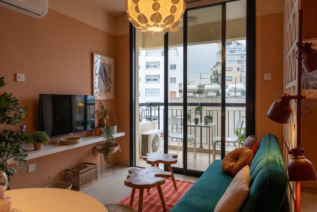 a living room with a blue couch and a large window at Johny's Spot in Larnaca in Larnaca