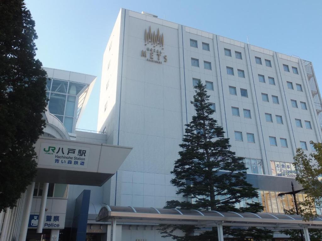 ein Gebäude mit einem Weihnachtsbaum davor in der Unterkunft JR-EAST HOTEL METS HACHINOHE in Hachinohe