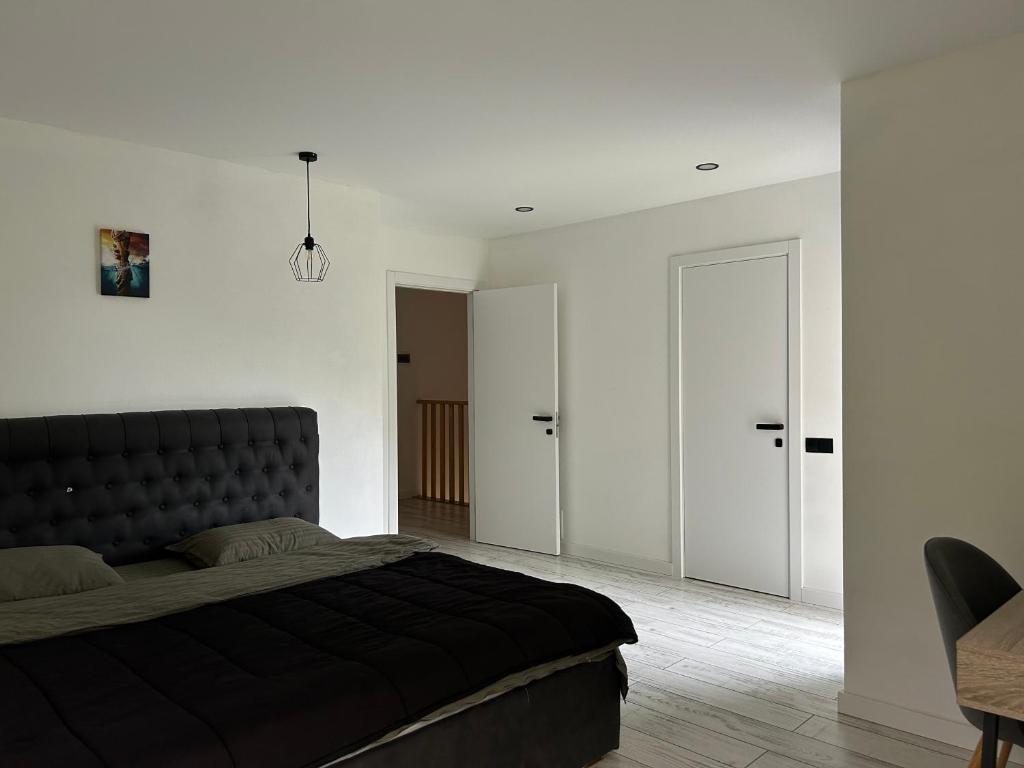 a bedroom with a black bed and white walls at Villa Bory in Vygoda