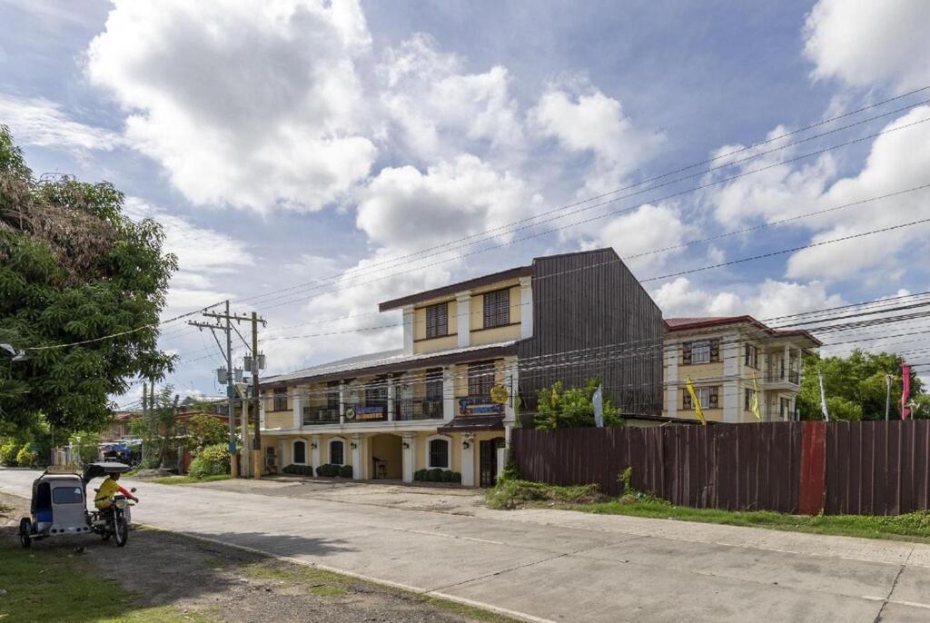 a man on a bike parked in front of a house at Metro Vigan Inn MAIN in San Vincente