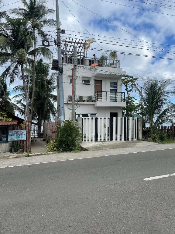 a white house with a fence and palm trees at Tyne Haven in San Juan