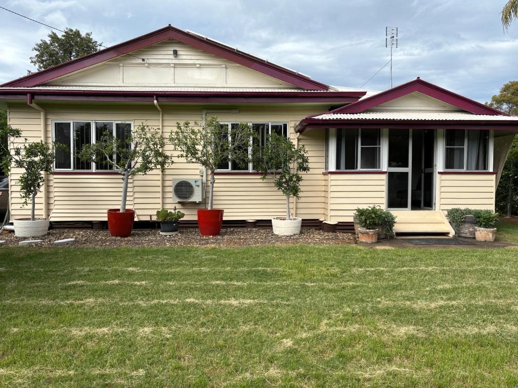 a house with potted plants in front of it at Dalby home in Dalby