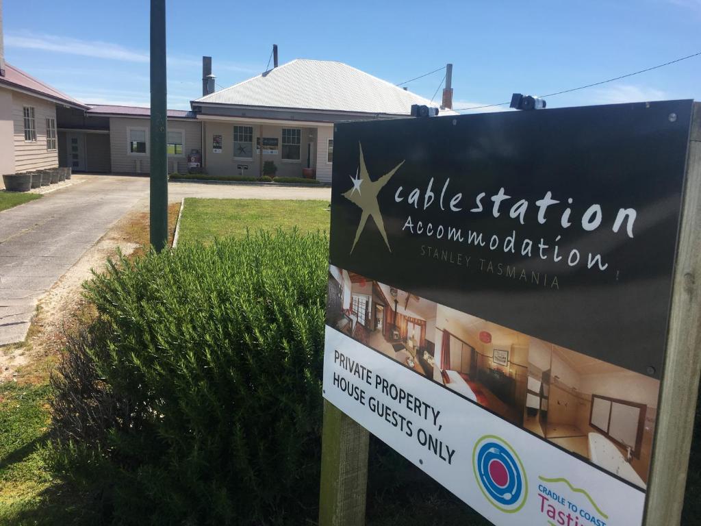 a sign in front of a building at Cable Station Accommodation in Stanley