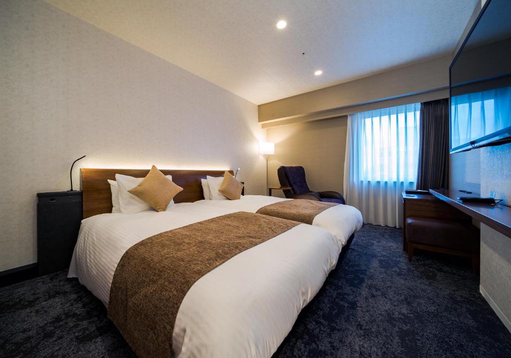 a hotel room with a large bed and a television at Daiwa Roynet Hotel Nagoya Taiko dori Side in Nagoya