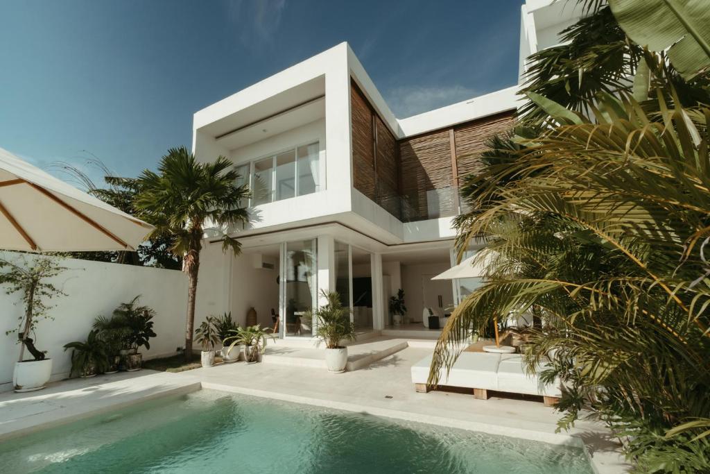 a house with a swimming pool in front of it at The Iggy Villa 2BR in Cemagi