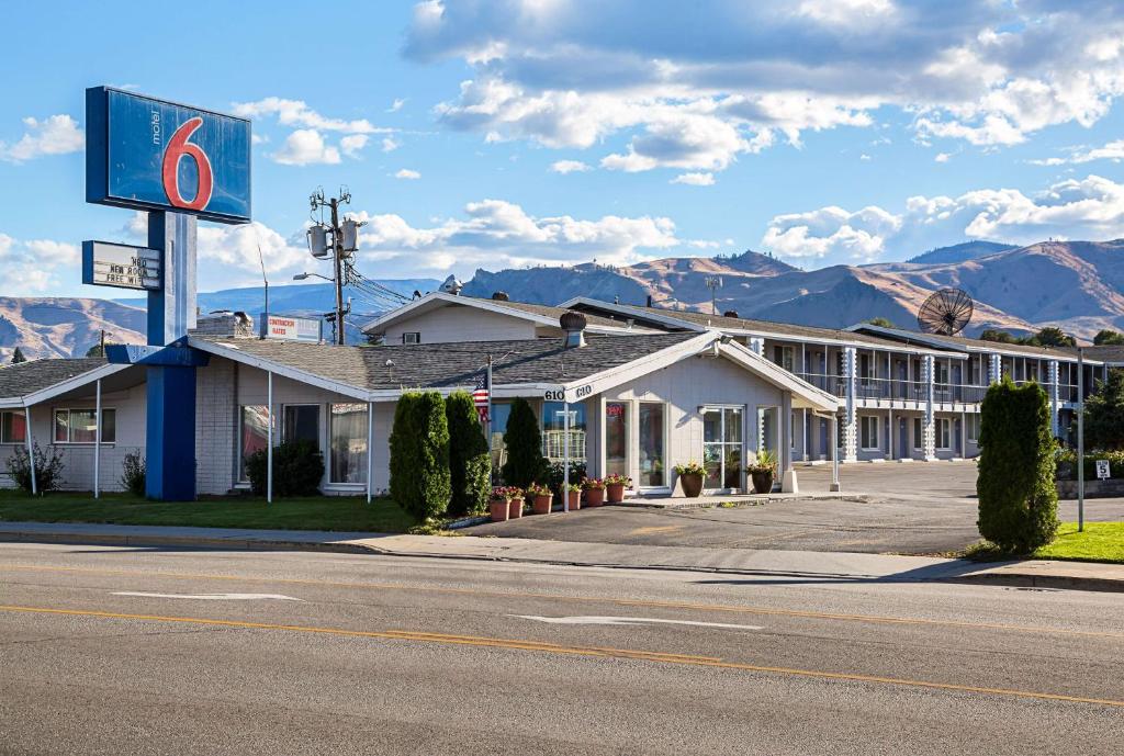 a hotel on the side of a road with mountains at Motel 6-Wenatchee, WA in Wenatchee