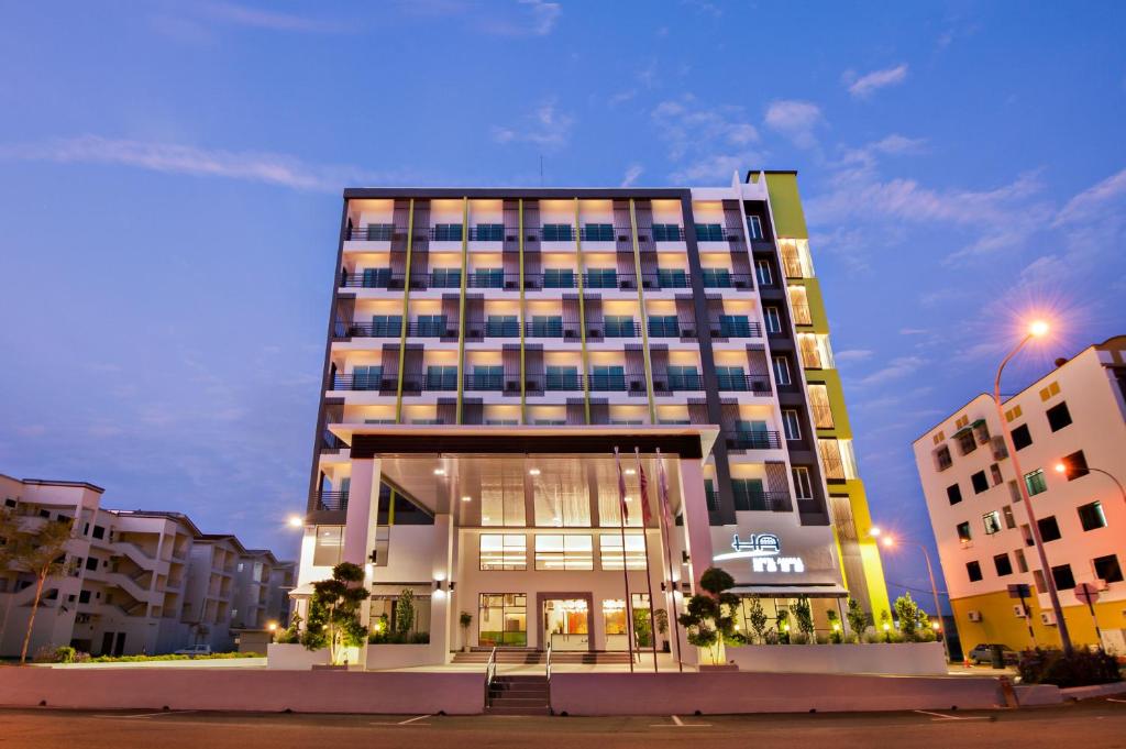 a tall building in a city at night at Hotel Arissa in Malacca