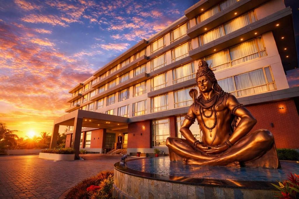 a statue in front of a building with a sunset at The Somnath Gateway in Somnath