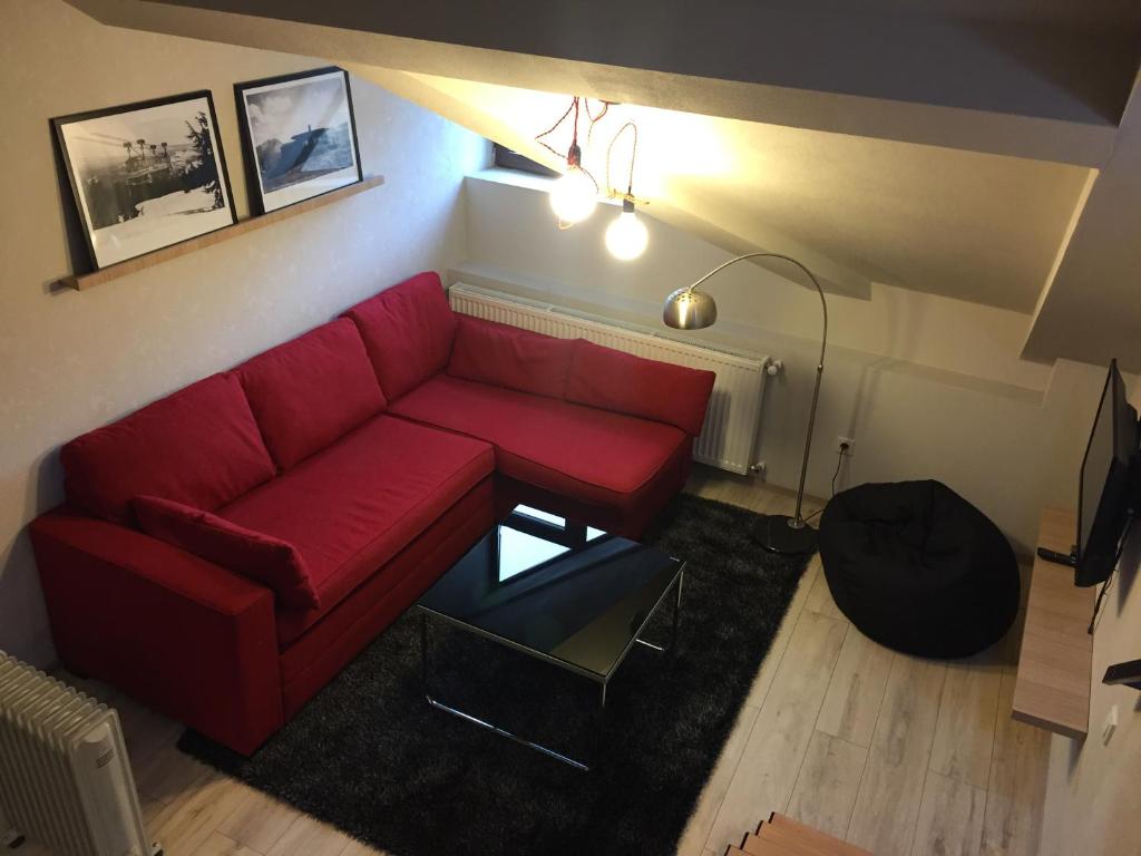 a living room with a red couch and a table at Two Level Apartment near Gondola in Gudauri