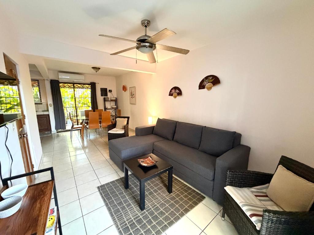 a living room with a couch and a ceiling fan at Pineapple Condo at Villa Riviera in Coco