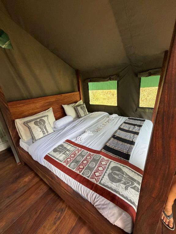 a bed in a tent in a room at Tangi Elephant Camp in Pakwach East
