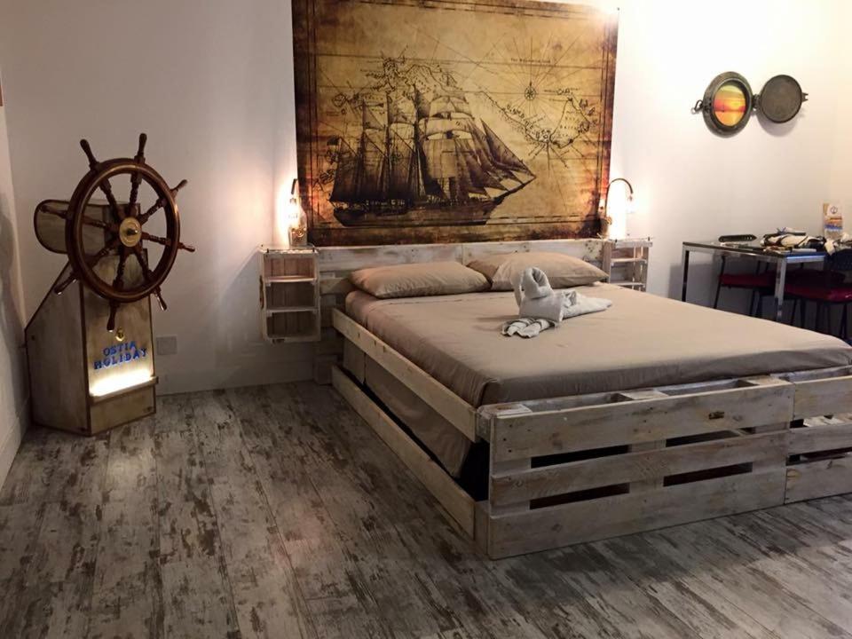 奧斯蒂亞的住宿－Appartamento Levante，卧室配有一张大床,墙上挂有绘画作品