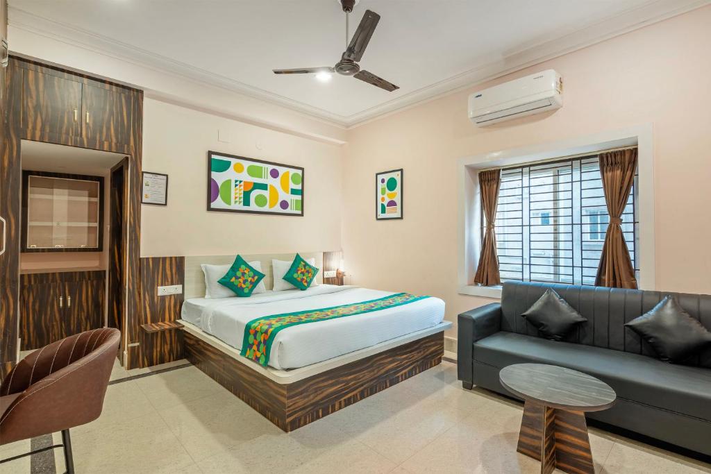 a bedroom with a bed and a couch at Treebo Sri Krishna Palace in Bhubaneshwar