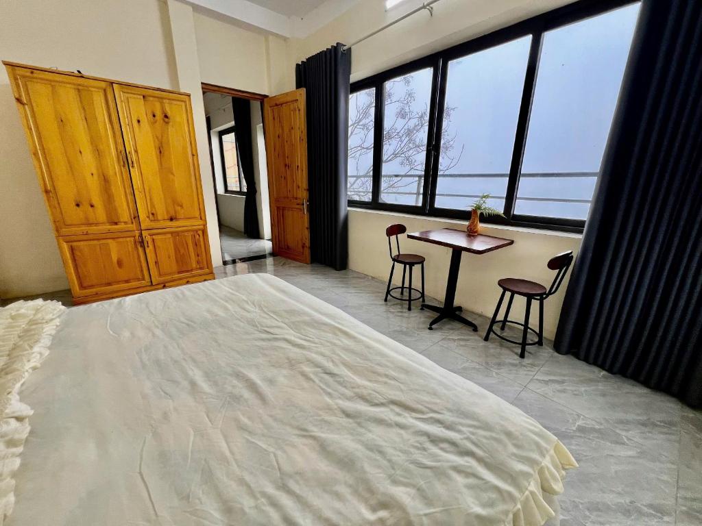 a bedroom with a large bed and a table with chairs at Lùma Sapa Homestay in Sapa