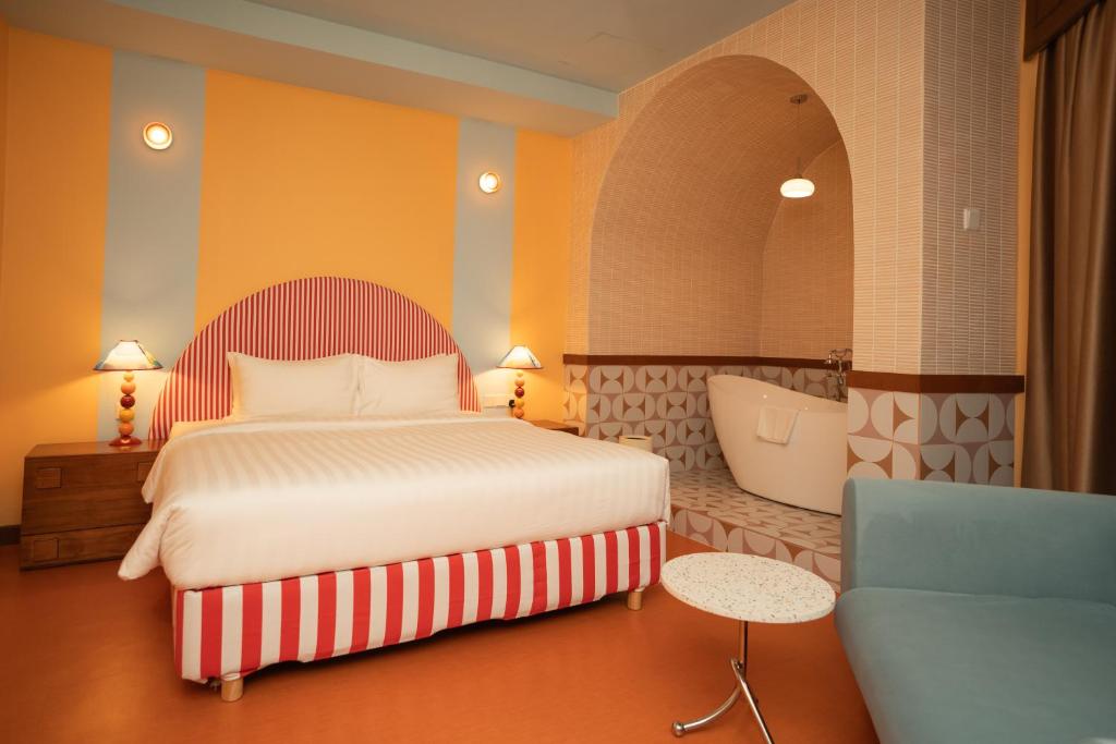 a bedroom with a bed and a bath tub at The Très Hotel in Kuala Lumpur