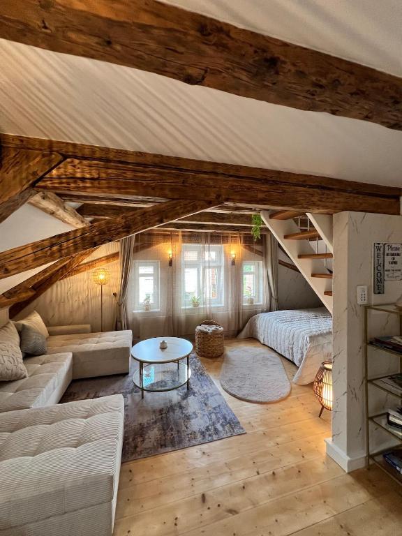 a living room with a couch and a table at Casa Ribeiro Sotao in Bischberg