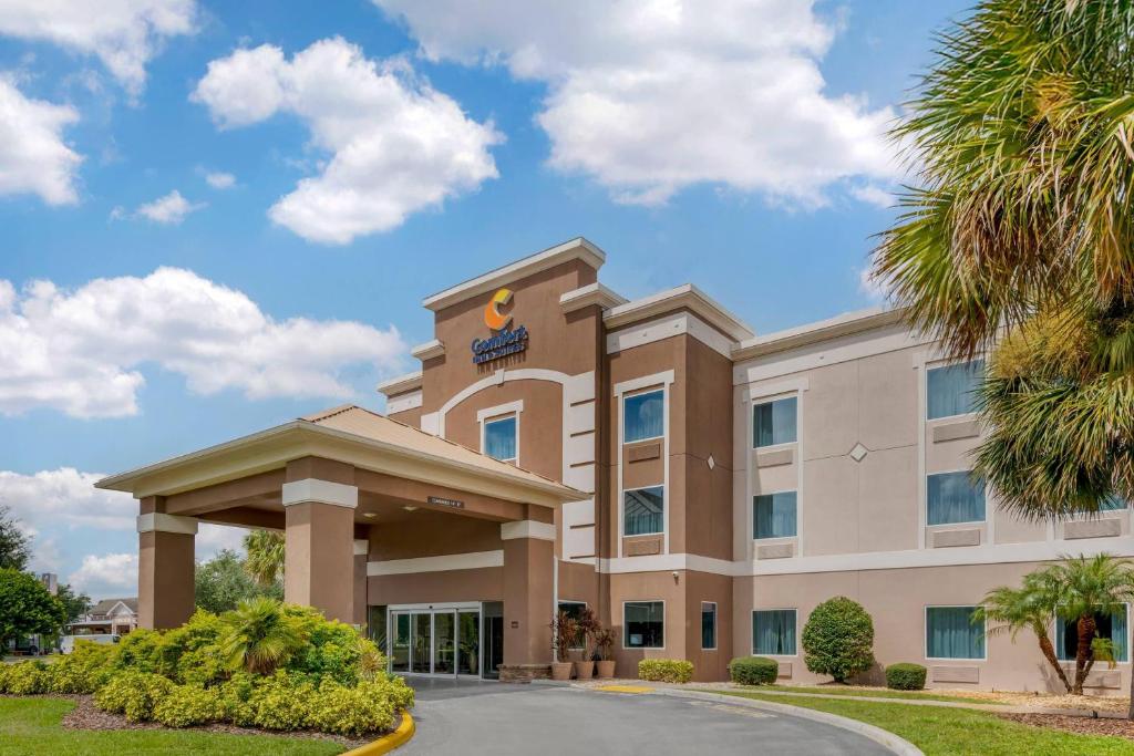 a hotel building with a palm tree at Comfort Inn & Suites Wildwood - The Villages in Wildwood