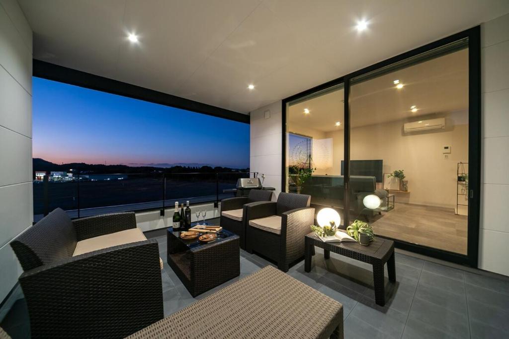 a living room with couches and a large window at Seven Saunas Village in Arao