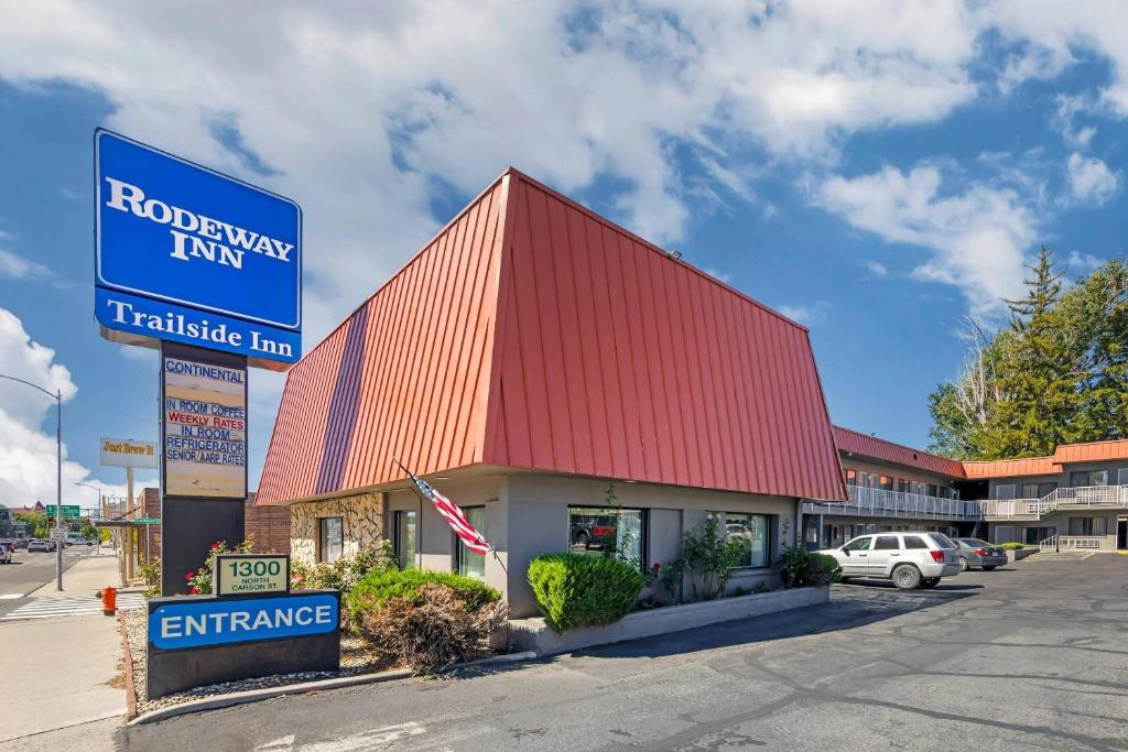 a building with a red roof in a parking lot at Rodeway Inn at Nevada State Capitol in Carson City