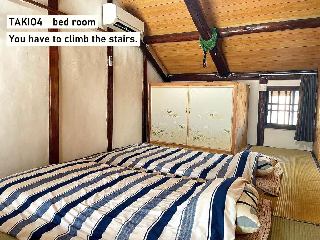 a bedroom with a bed with a blue and white stripes at TAKIO 4 guesthouse in Higashi-osaka