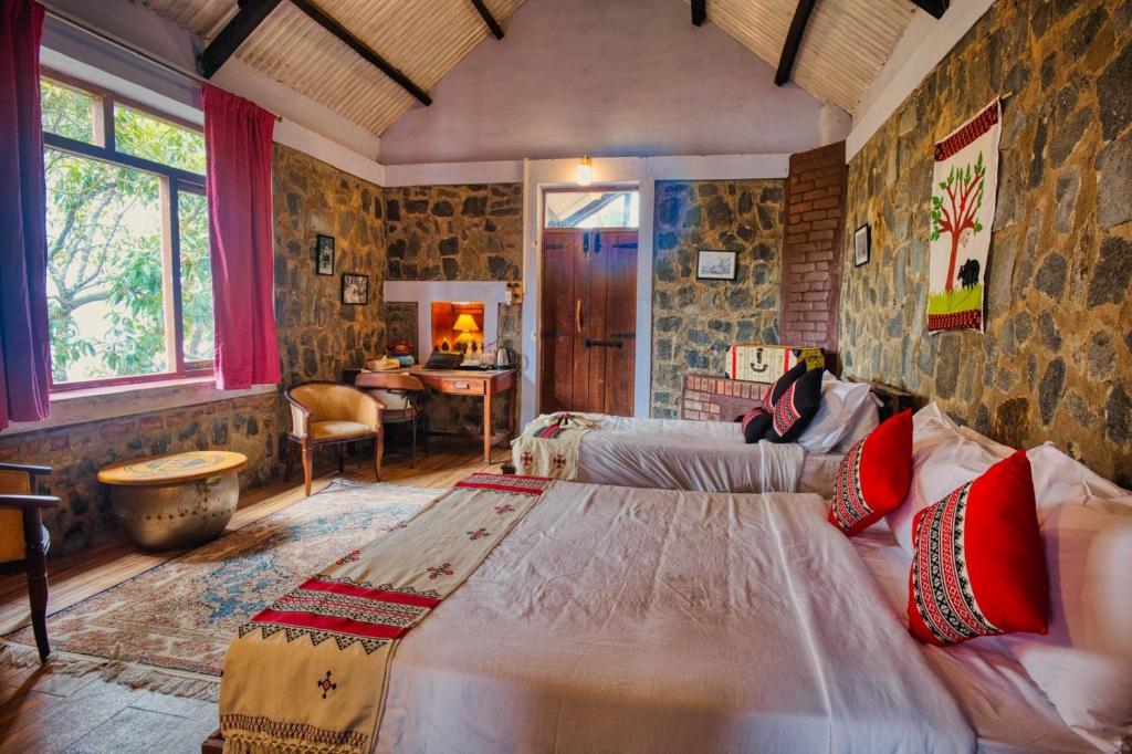 a bedroom with a large bed in a room at Hullathy by Red Earth in Ooty