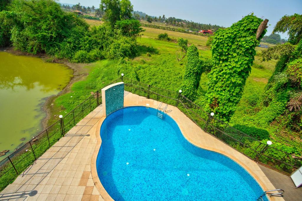 an overhead view of a swimming pool next to a river at Aveeno Resort with Swimming Pool and Jacuzzi Near Calangute and Baga in Sangolda