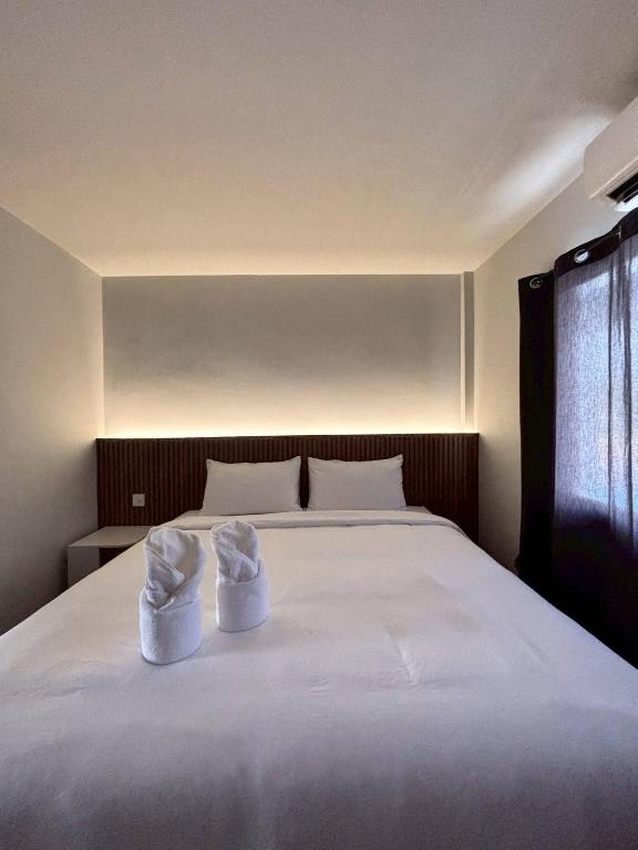 a bedroom with a bed with two white towels on it at Ma Relax Place in Ban Nong Chaeng