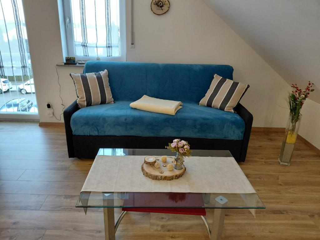 a living room with a blue couch and a coffee table at Hinter-Apartments-Nord in Rohrbach