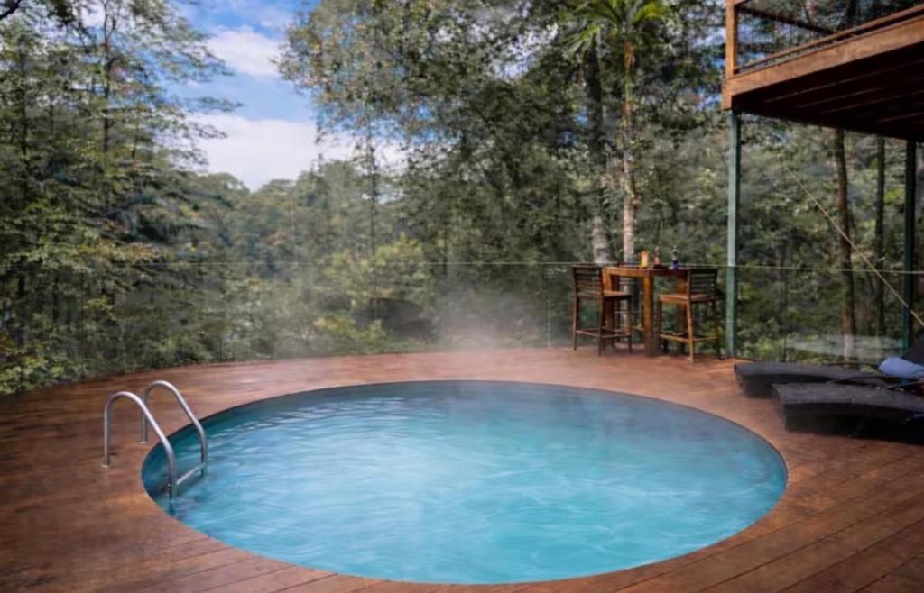 a swimming pool on a deck with a hot tub at Addisons Baroon A Rainforest Retreat with Heated Plunge pool in Montville