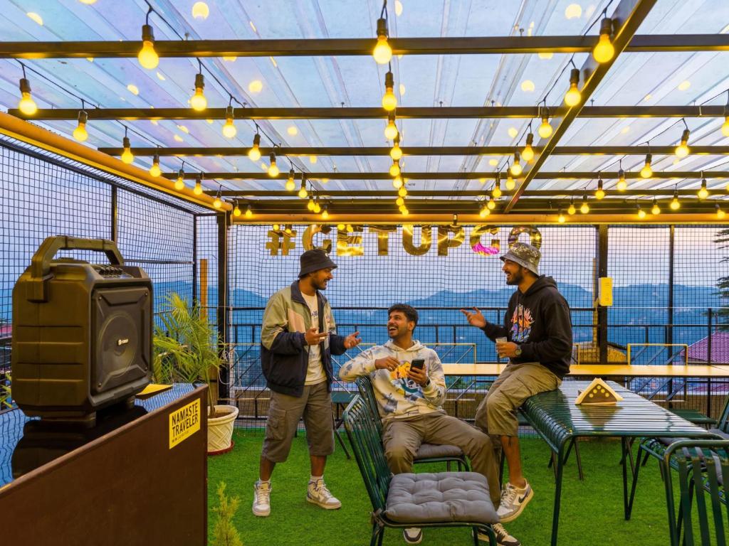 a group of men sitting in a room with a tv at The Hosteller Shimla in Shimla