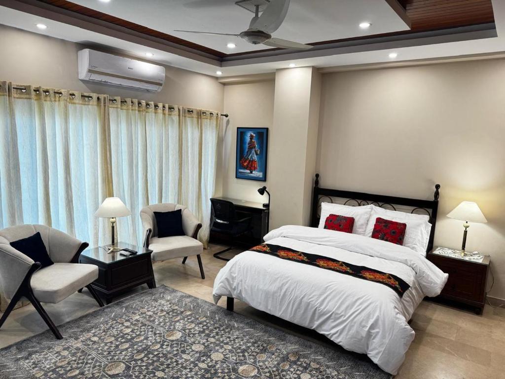 a bedroom with a bed and two chairs and a couch at Pent House Executive Resedency in Dargai