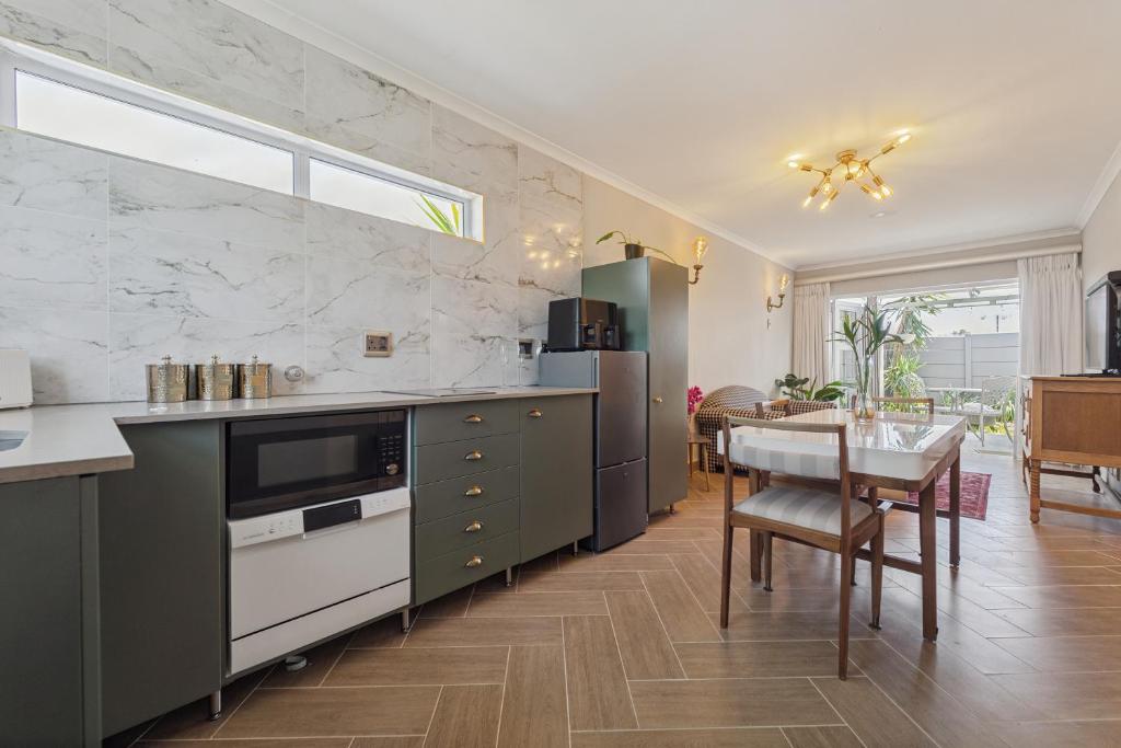 a kitchen with a table and a dining room at Lloyd's Corner in Cape Town