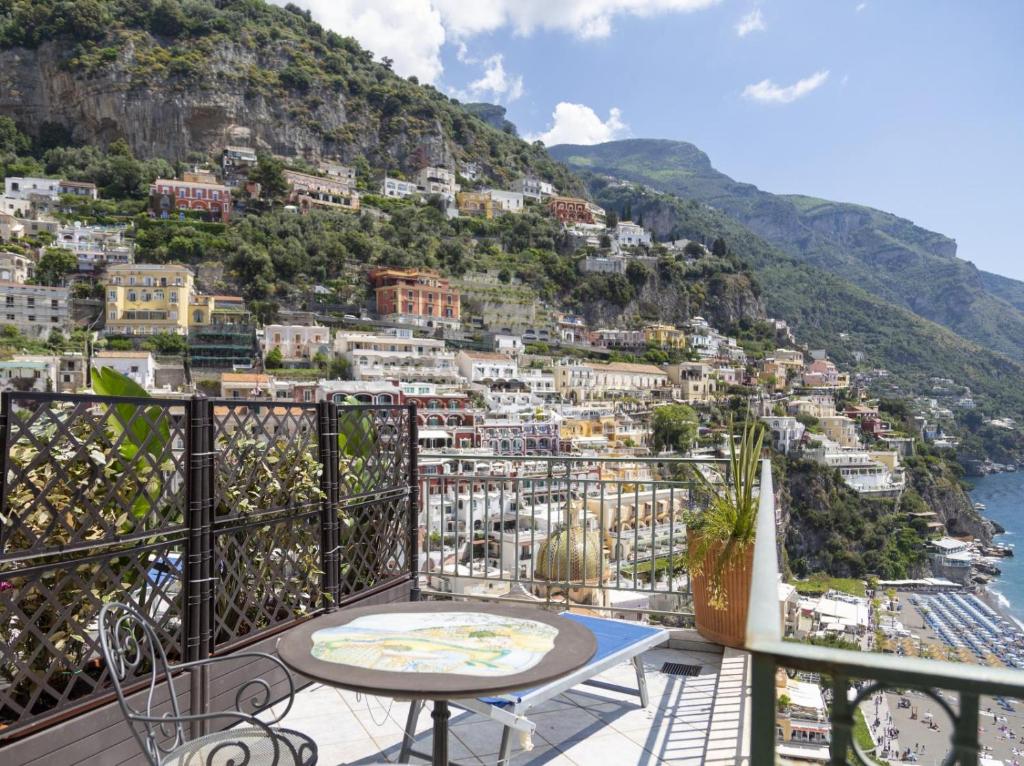 a balcony with a table and a view of a city at Hotiday Positano Sea View in Positano