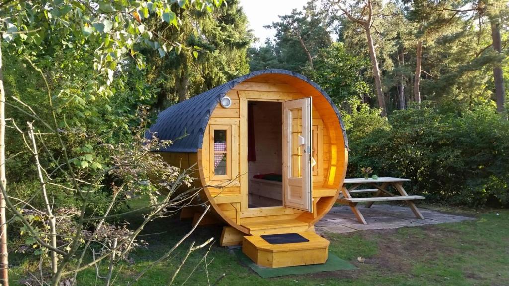 a small wooden house with a picnic table in a yard at Campingfass im Naturresort Weserinsel in Langwedel