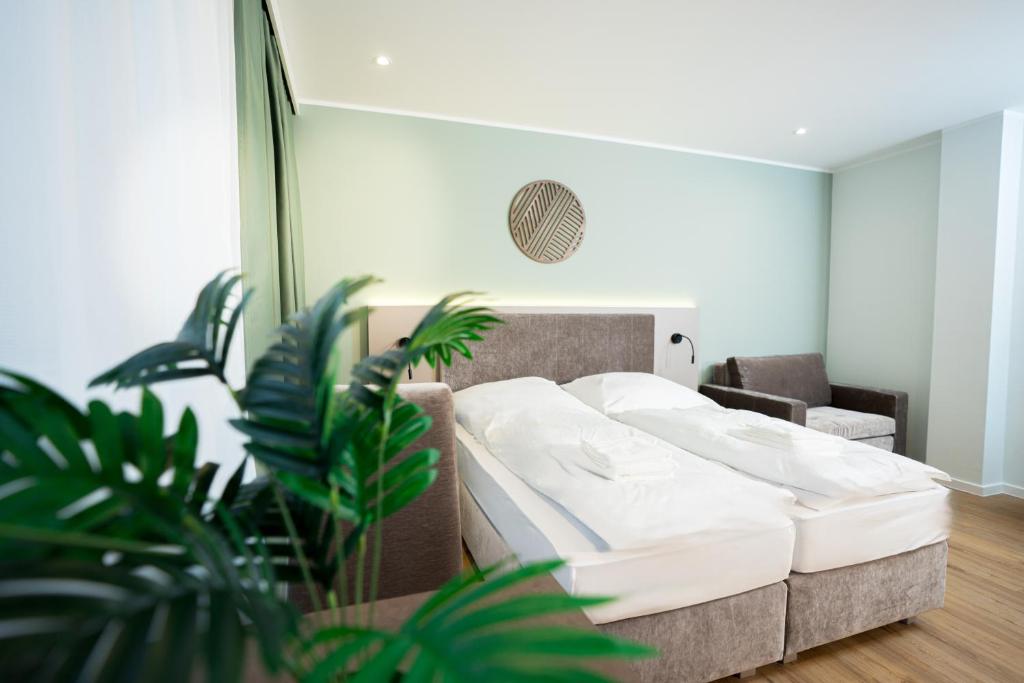 a bedroom with a large bed with white sheets at Living Inn am Schlosspark - Zentral, Parkplatz und Kitchenette in Rheda-Wiedenbrück