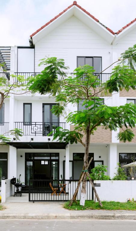 a house with a tree in front of it at Cloud Inn Homestay in Thôn Lại Thê