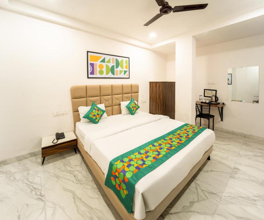 a bedroom with a large bed and a desk at Treebo Shridhar Stay, 2 km from Indore Junction in Indore