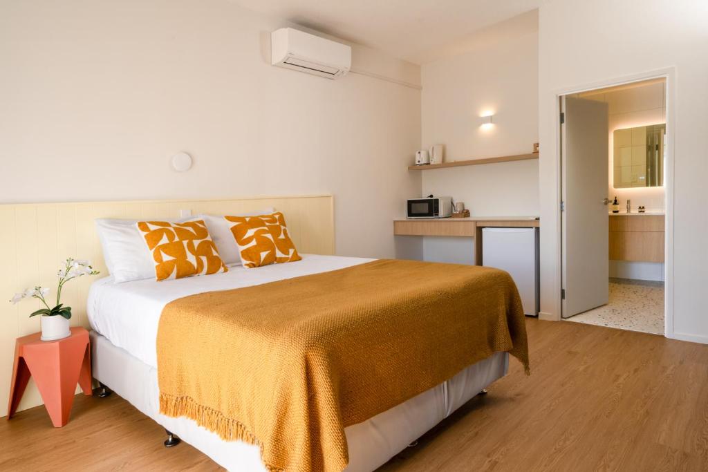 a bedroom with a large bed with orange pillows at Mt Wellington Motel in Auckland