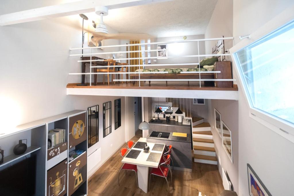 a loft apartment with a staircase and a dining room at Casa degli Specchi- Duplex in Arona city center - By Guestaly in Arona
