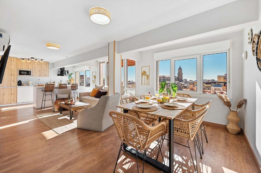 a dining room and living room with a table and chairs at Merced luxury in Málaga