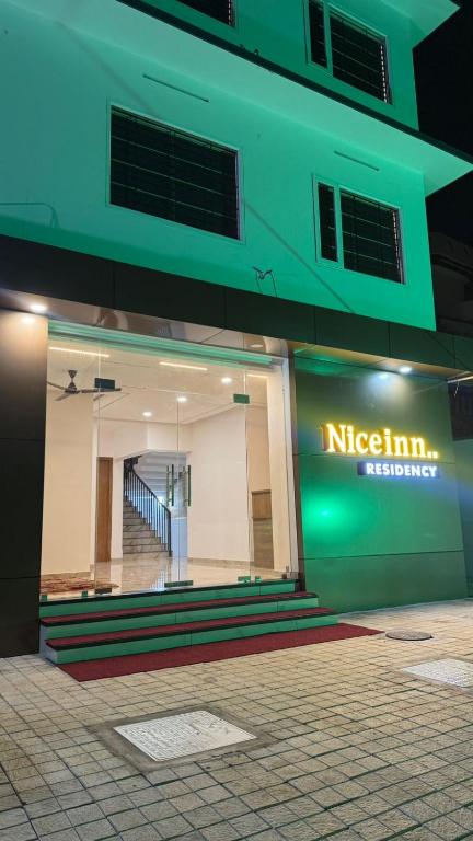 a building with a sign on the side of it at Nice Inn Residency in Kozhikode