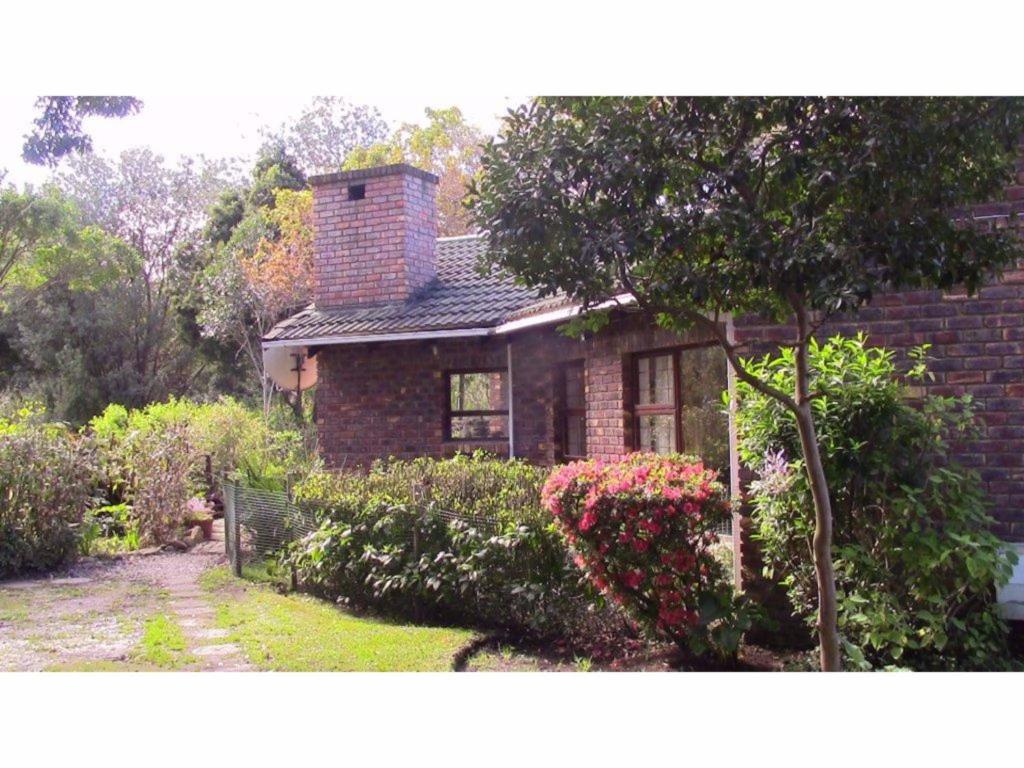 a brick house with a chimney on top of it at Forest Nest Cottage, Tsitsikamma in Stormsrivier