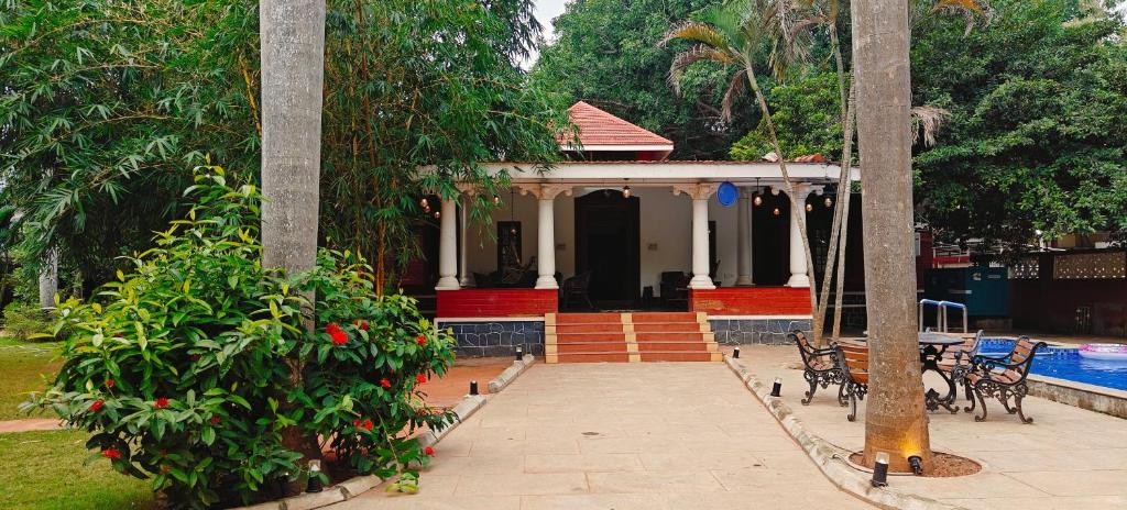 a house with a porch and a swimming pool at Sun Private Pool Villa in Puducherry Airpoert