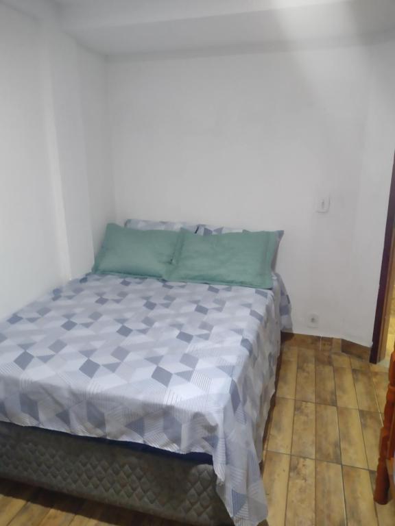 a bed in the corner of a room at Casa temporada próximo a praça do canhão in São Pedro da Aldeia
