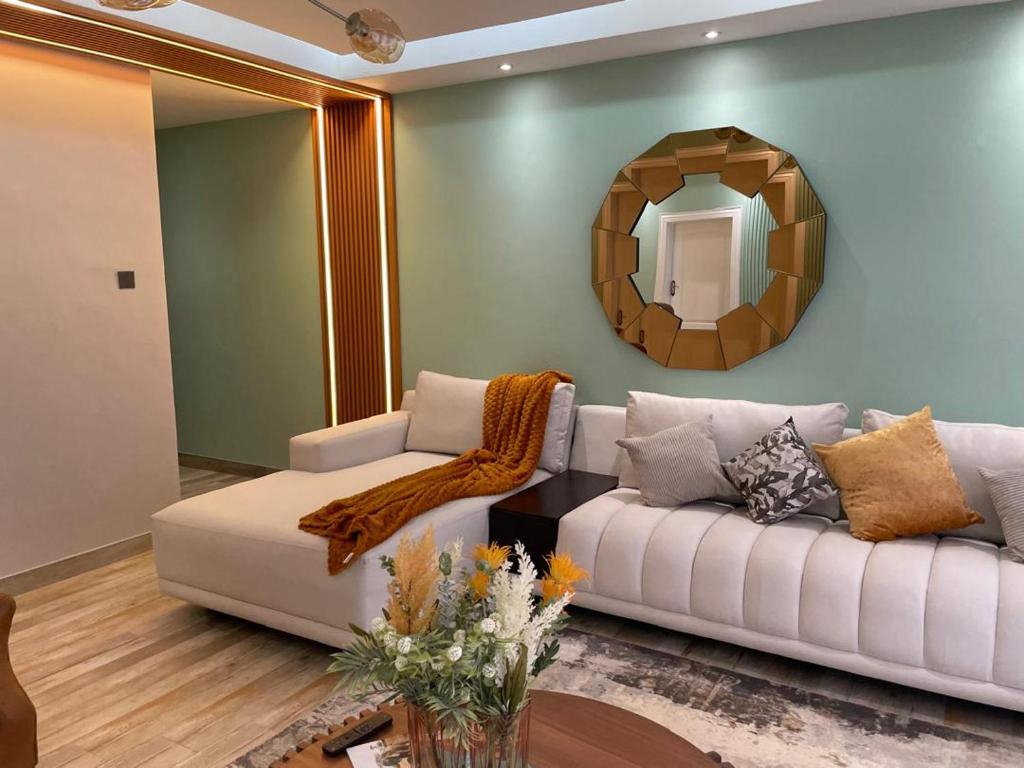 a living room with a white couch and a mirror at Muyeni BnB in Harare