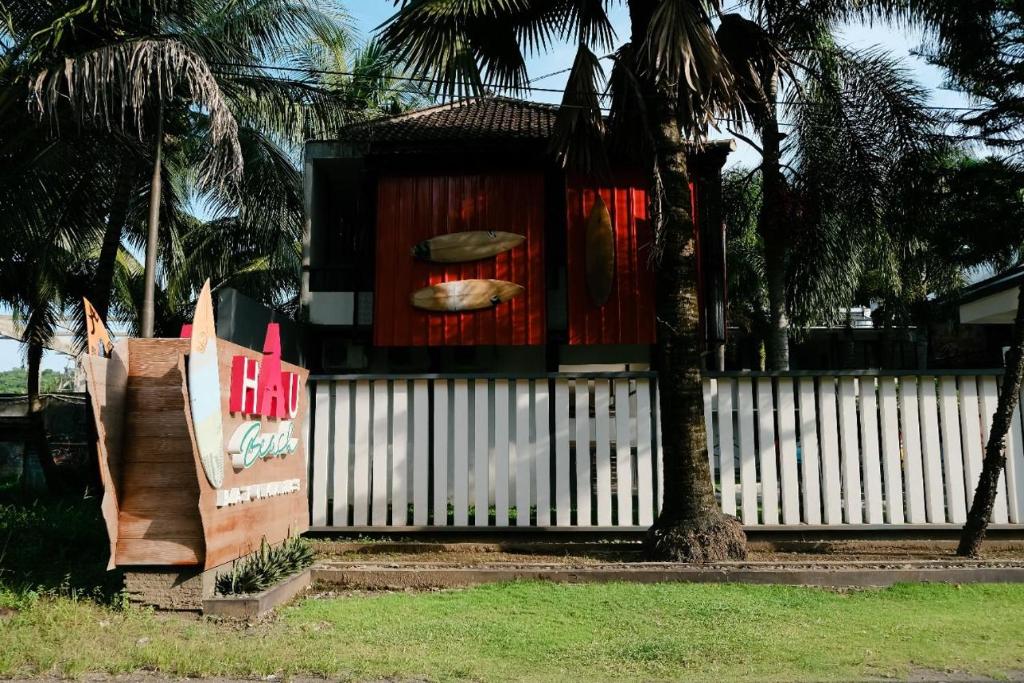 a house on a fence with a surfboard on it at Hau Batu Karas in Batukaras
