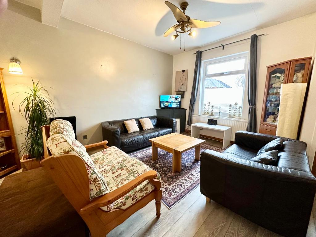 a living room with a couch and a table at Comfortable rooms Manchester in Manchester